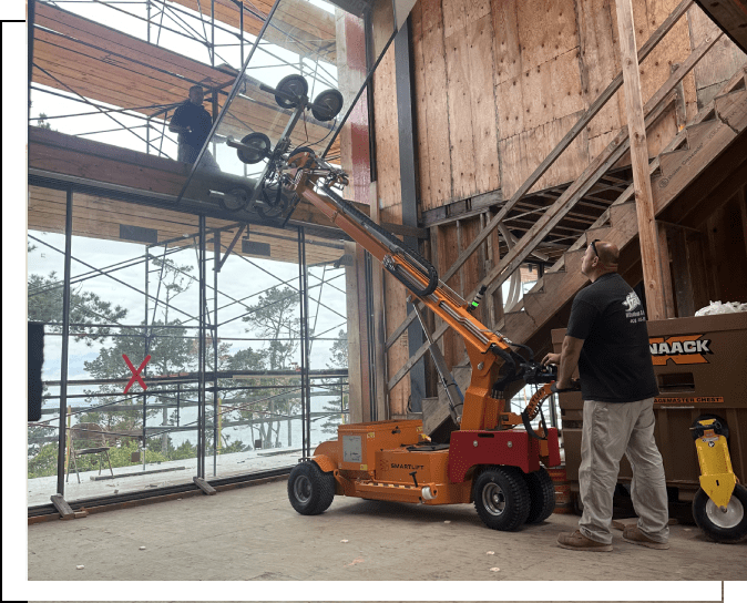 A man standing next to an orange crane.