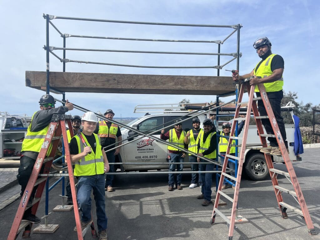 A group of people standing around on scaffolding.