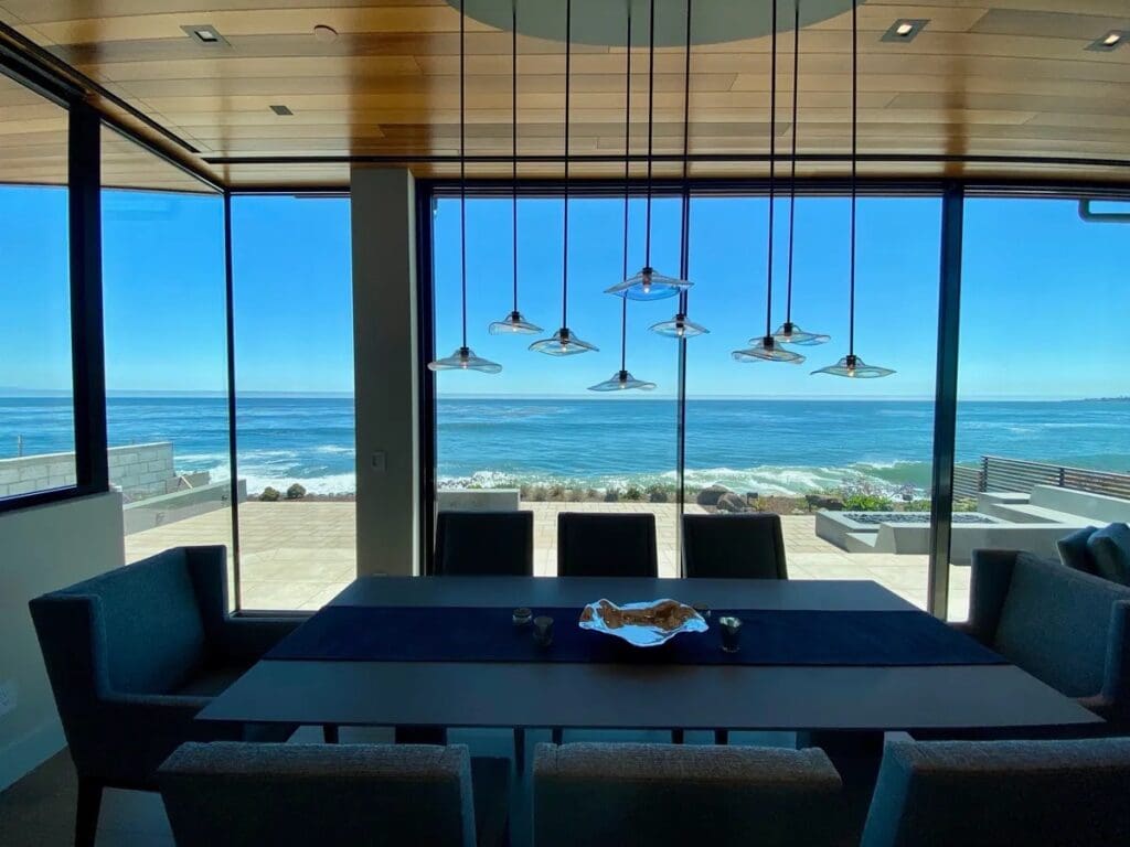 A table with chairs and lights hanging from the ceiling.