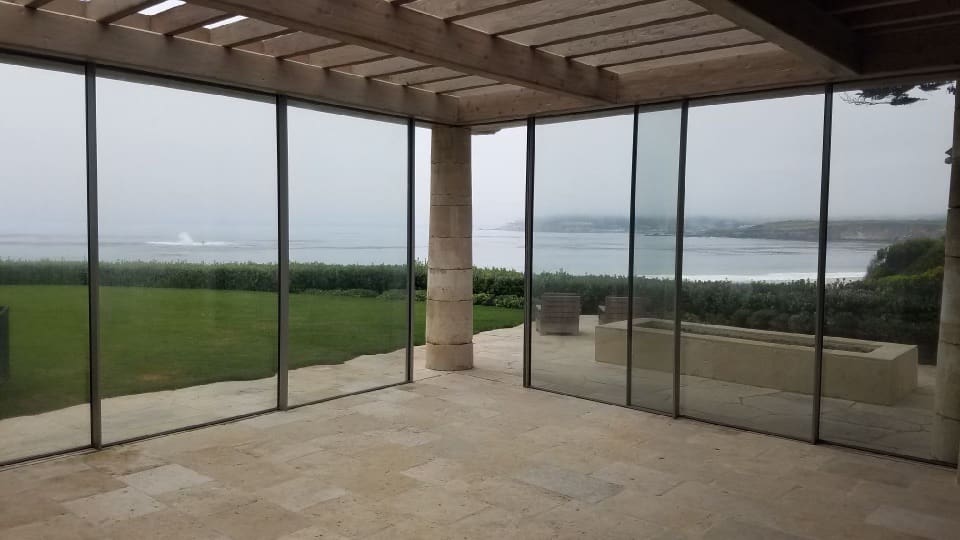 A patio with sliding glass doors and a view of the ocean.