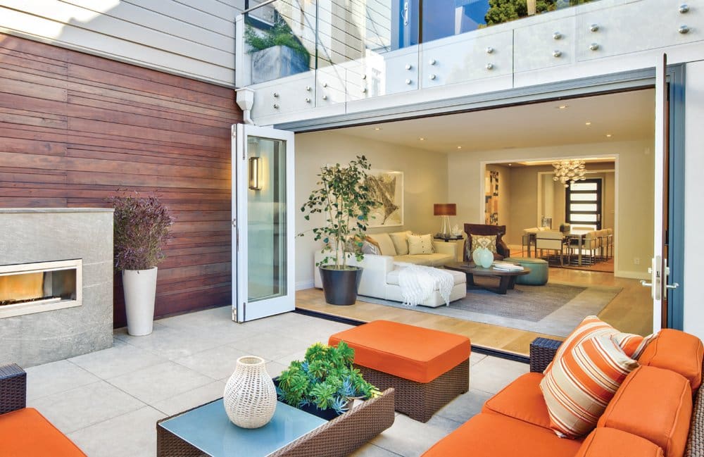 A living room with orange furniture and a large open door.