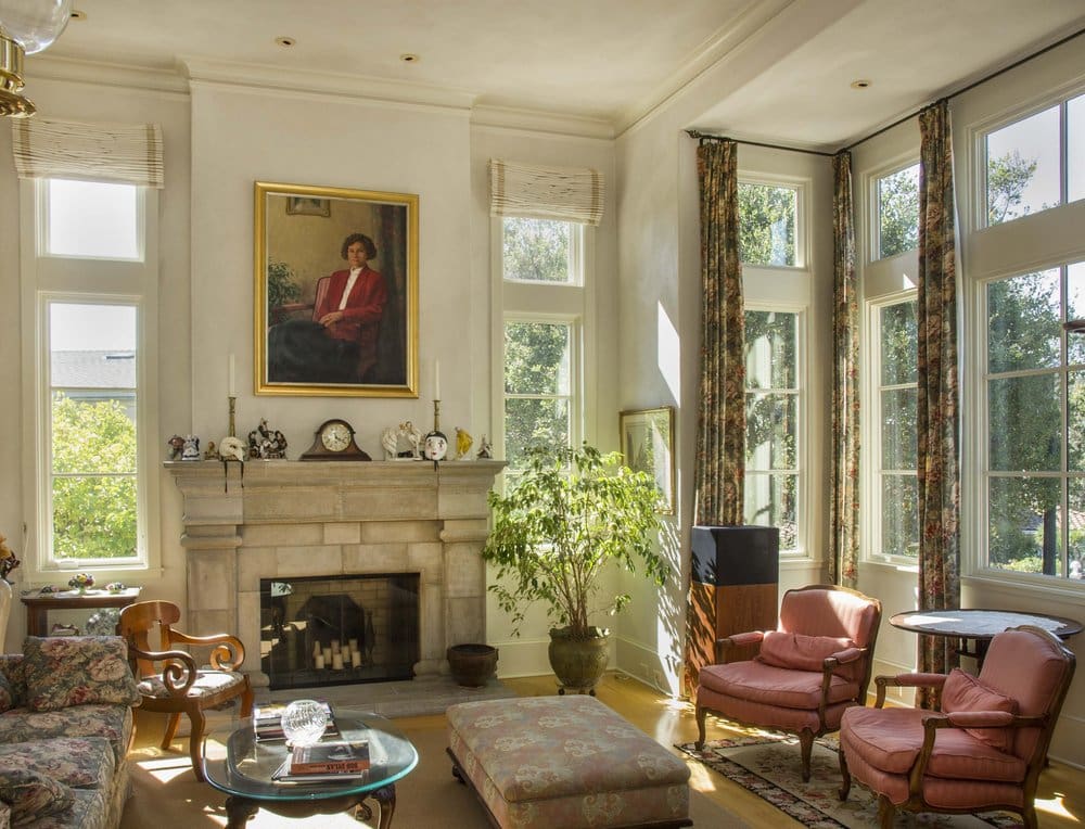 A living room with a fireplace and many windows