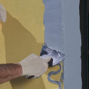 A person is painting the wall with a paint roller.