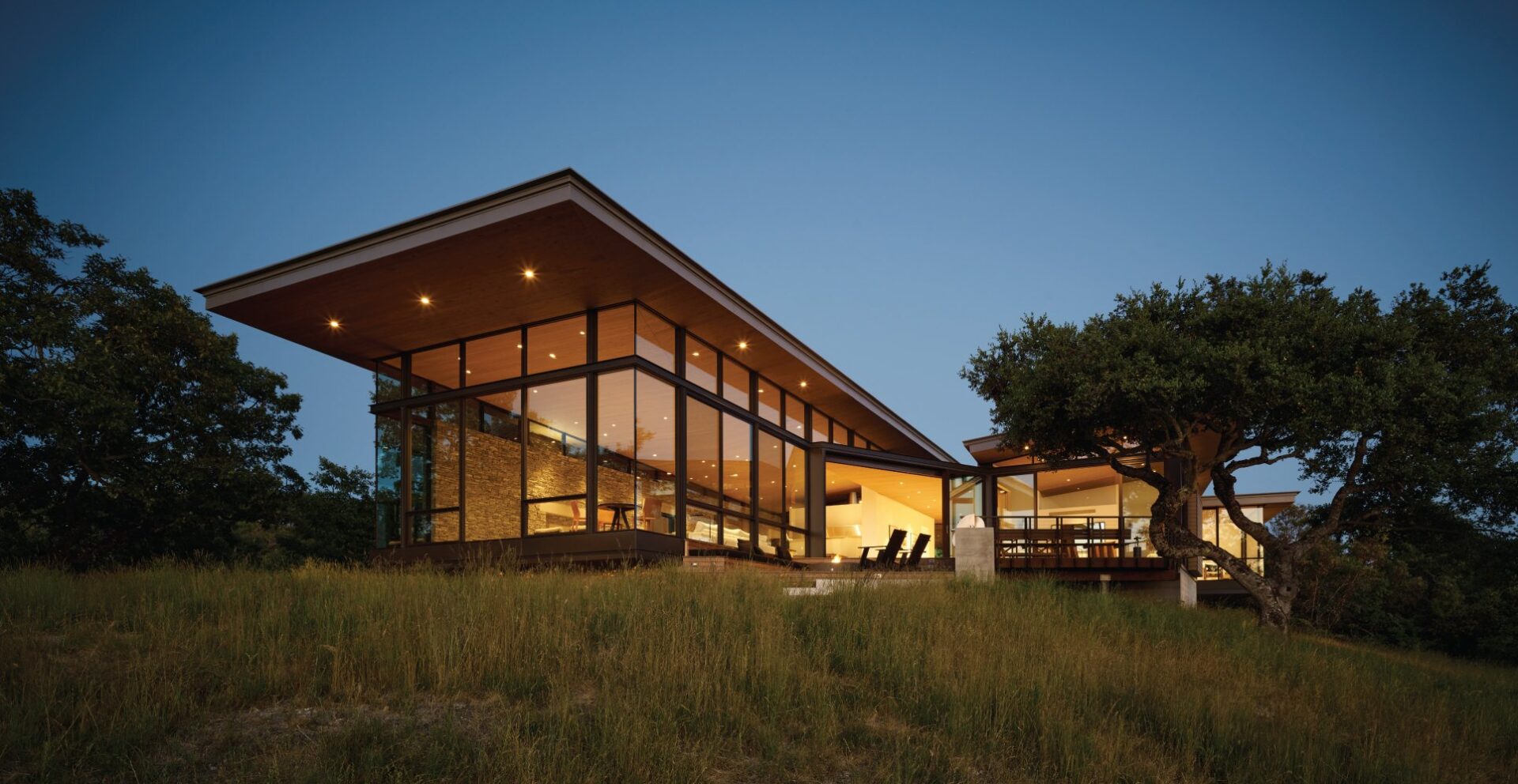 A large building with glass windows and a grassy area.