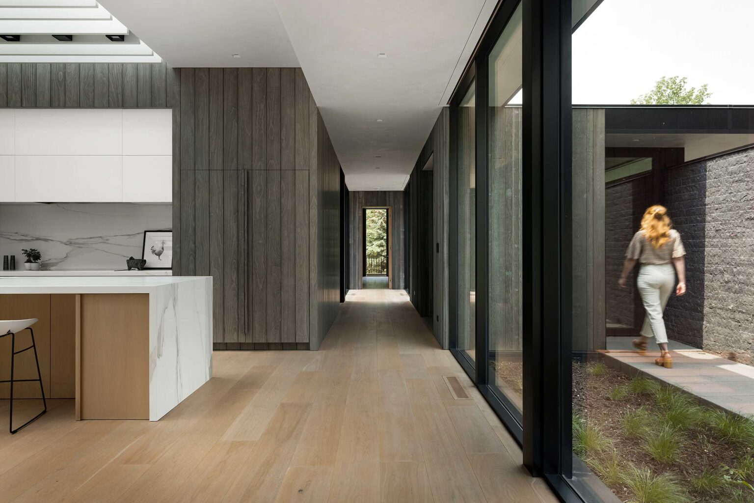 A long hallway with sliding glass doors leading to the kitchen.