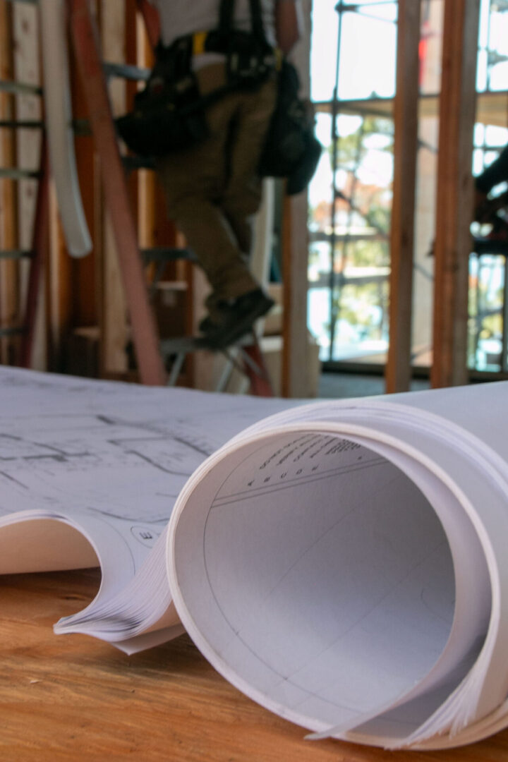 A roll of paper on top of some construction plans.